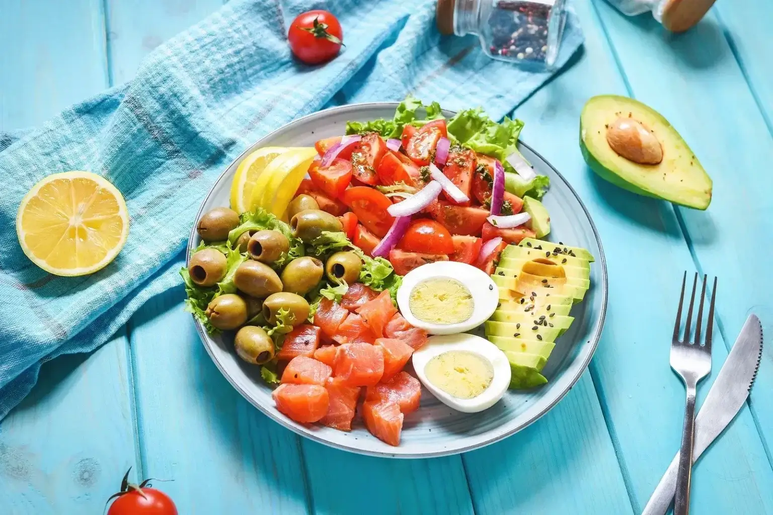 Farebný tanier so zeleninou, vajíčko, avokádom, olivami a údeným lososom – ukážka odporúčanej stravy pri diéte proti kandidóze.