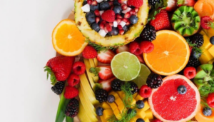 Mix čerstvej zeleniny, ovocia, orechov a celozrnných potravín bohatých na vitamíny, znázorňujúci dôležitosť vitamínov pre zdravie a energiu človeka.