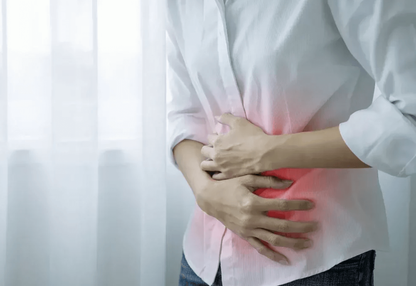 Osoba si drží brucho v oblasti bolesti, zvýraznená červená farba symbolizuje tráviace ťažkosti a bolesti brucha – najčastejšie ochorenia tráviacej sústavy.