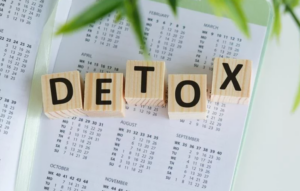 Kocky s písmenami tvoriacimi slovo „DETOX“ na kalendári – symbolizujú proces očisty organizmu a plánovanie zdravého životného štýlu.